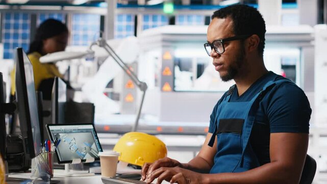 Solar energy expert updates design models in eco friendly factory with a focus on research and innovation. Male worker supports sustainable industrial growth using digital systems. Camera A.