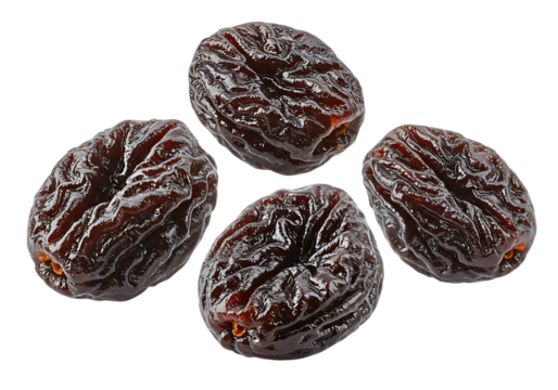 Close up of four delicious and fresh dried plums on a stark black background