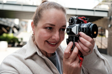 Photographer using vintage analog 35mm camera, capturing moments with retro film charm