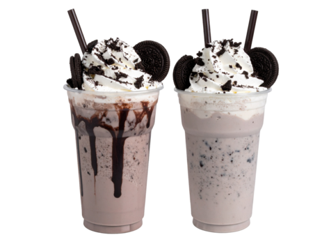 Two creamy chocolate milkshakes topped with whipped cream and chocolate cookies in clear plastic cups with straws