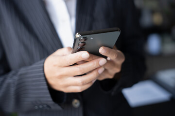 Asian Business woman using smart phone spending time checking news social media