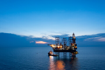 Aerial view of offshore jack up drilling rig during sunset - oil and gas industry.