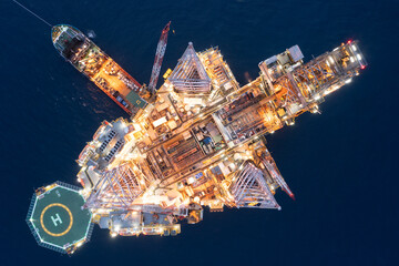 Aerial view of offshore jack up drilling rig during sunset - oil and gas industry.