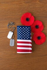 Obraz premium Remembrance day composition with american flag poppies and military dog tags on wood