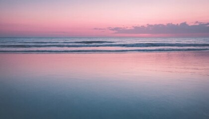 Obraz premium A serene sunrise paints the horizon orange over the calm sea, mirroring the sky as the sun begins its ascent, much like a peaceful sunset reflecting on a tranquil lake