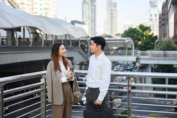 Obraz premium Businesspeople discussing work on footbridge in urban setting