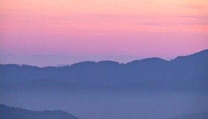 Naklejka premium Serene pink and purple hues over mountain silhouette at sunset or sunrise
