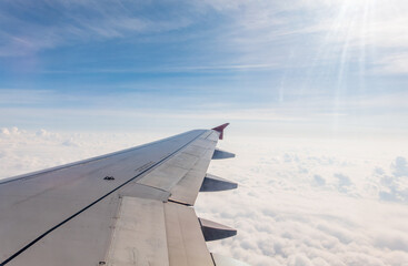 Obraz premium View from the airplane window at a beautiful cloudy sky and the airplane wing