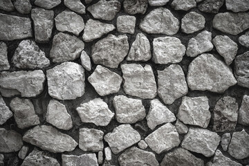 Empty monochrome black and white (grey) embossed stone on cement wall for abstract background and texture for interior or exterior design. Beautiful patterns, banner, wallpaper close up.