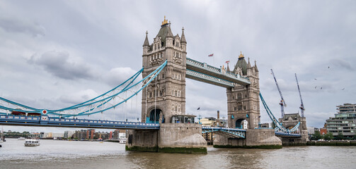 Obraz premium Tower Bridge Spans the Thames with Its Gothic Towers and Blue Cables, Remaining a Must-See Symbol of the City for Visitors in July 2023