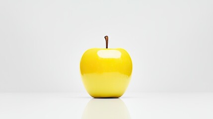 Obraz premium A beautiful and ripe yellow apple stands on a white surface