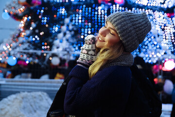 beautiful girl in winter hat near the Christmas tree, winter holidays, holiday and walks photo...