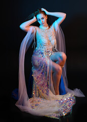 Fantasy studio portrait of a red-haired mermaid faery model wearing a white pearl gown, fairytale...