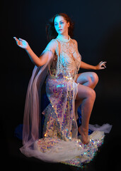 Fantasy studio portrait of a red-haired mermaid faery model wearing a white pearl gown, fairytale...