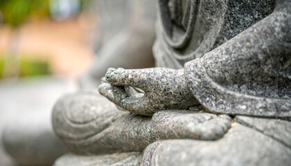 Close-up detail of a stone Buddha meditating, showcasing serenity and spiritual depth. Perfect for backgrounds aiming to evoke inner peace.