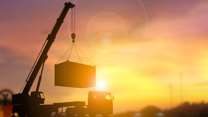 Silhouette of Crane Truck Lifting Cargo Container at Sunset