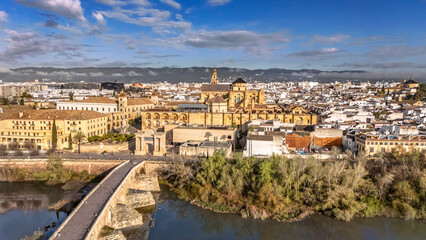 Obraz premium Aerial drone view of cityscape of Cordoba with Mosque-Cathedral, Mezquita Cathedral, roman bridge and Guadalquivir river, skyline of Cordoba, Andalusia, Spain
