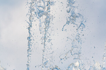 Splashes and jets of water against light background.