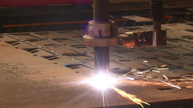 The hi-technology sheet metal manufacturing process by laser cutting machine. Close-up of laser cutting machine with flying sparks. CNC plasma cutter cut metal sheet. Gas cutting process at factory
