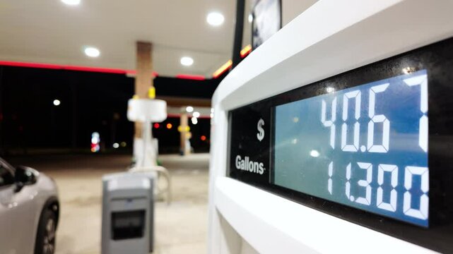 Close up footage of Petrol station with running numbers on gas pump at night time