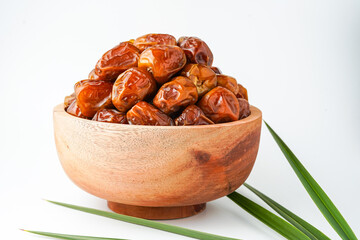 Dates fruit sukari or kurma sukari, in wooden bowl isolated on white background