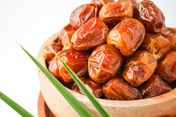 Dates fruit sukari or kurma sukari, in wooden bowl isolated on white background