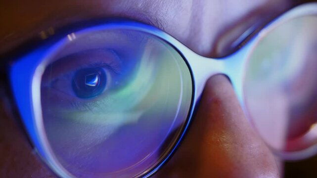 The close up of woman eyes looking through glasses at flashing sliding lights