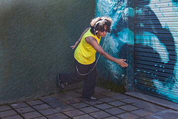Young man with headphones dancing in the street