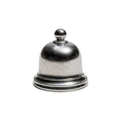 Antique silver bell rests on a white surface, its dome shape and small spherical knob reflecting light, highlighting its vintage charm and simple elegance.