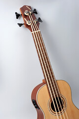 Four-string bass ukulele with wooden body and built-in tuner and pickup.