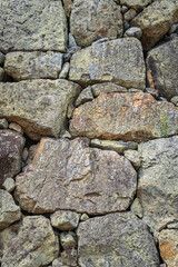 Close-up view of an old stone wall with large, weathered rocks stacked tightly together
