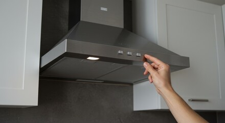Photo of Hand Turning On Stainless Steel Exhaust Hood in Kitchen
