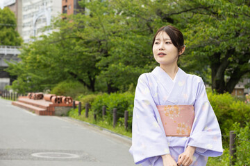 公園を歩く着物を着た若い日本人女性