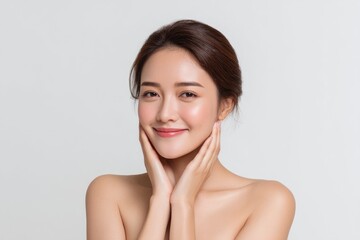 Obraz premium Woman Touching Face Smiling with Bare Shoulders Portrait
