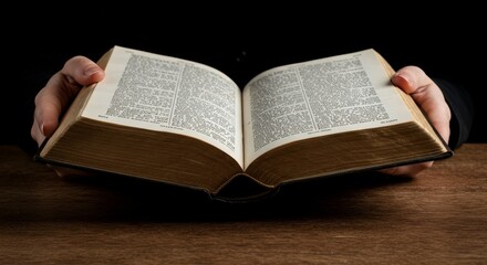 Obraz premium Photo of Hands Holding an Open Antique Book on a Wooden Table