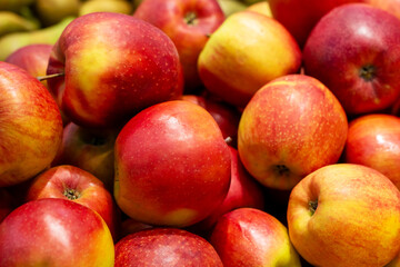 A colorful pile of red and yellow apples is sitting on top of each other