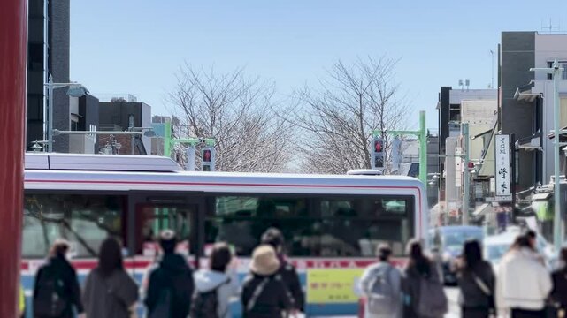青空の下、賑わう鎌倉の参道、人々とバスが行き交う