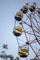 Colourful Ferris wheel cabins against a clear blue sky