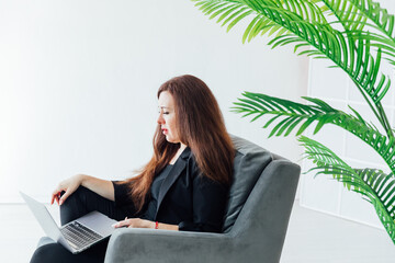 woman working on chair with laptop online from home