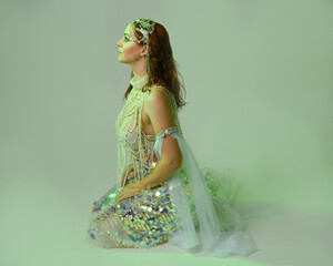 Fantasy studio portrait of a red-haired mermaid faery model wearing white pearl gown, fairytale...