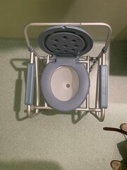 Overhead perspective of hospital commode chair with open seat designed for urine collection in male uroflowmetry tests.