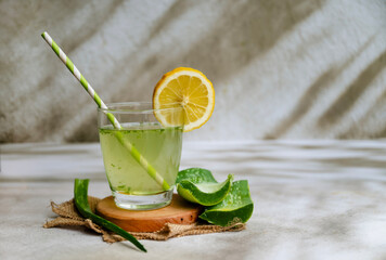 Fresh aloe vera drink in glass cup with aloe slices 