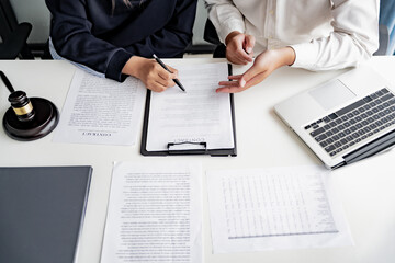Lawyer with lawsuit meeting with client discussing with contract agreement at law firm