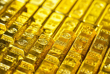 Stacking gold bars with golden light. Gold is hard commodity goods, risk asset, tangible value that...