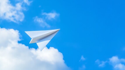 A single, white paper airplane is suspended against a bright, clear blue sky.