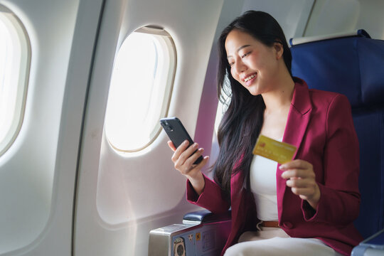 Businesswoman shopping online with credit card during flight