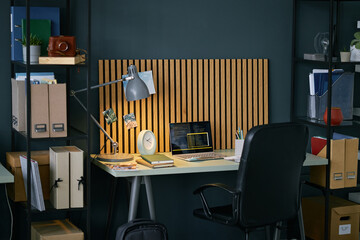 Neatly organized home office featuring wooden desk with computer setup, book, and potted plant on...