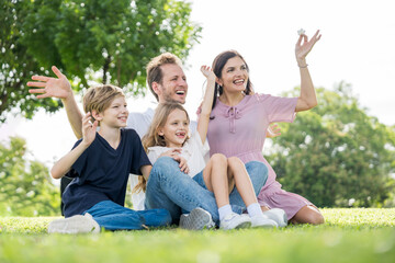Fototapeta premium Happy family parent children having picnic outdoor activity. Enjoy happiness moment summer playing together including father mother son and daughter relaxing in the morning sunrise.