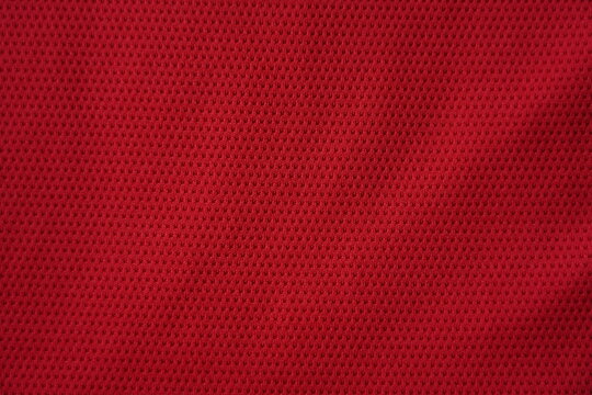 Close up of red football jersey sports clothing fabric texture.
