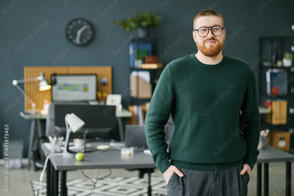 Poster portrait of gentleman with beard and glasses standing confidently in modern office. organized worksp
